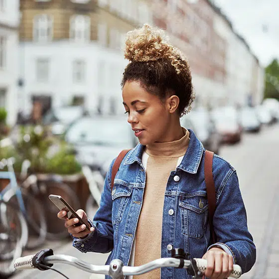 A young woman types on her iphone